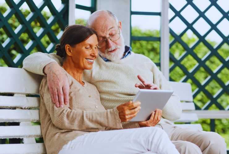 Due anziani al tablet sorridenti